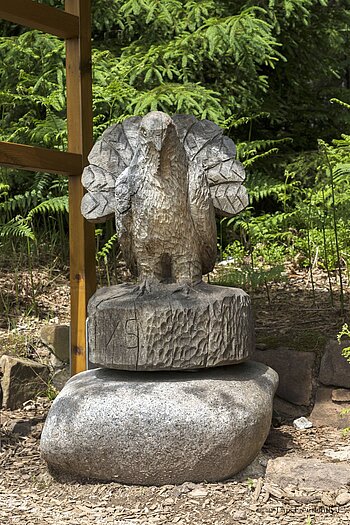 Holzskulptur eines Auerhahns auf dem Auerhahnweg