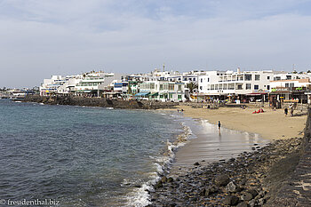 Blick über den kleinen Strand auf den Fischerort Playa Blanca
