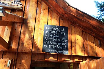 Tafel mit dem Öffnungszeiten der Schirrmaierhütte