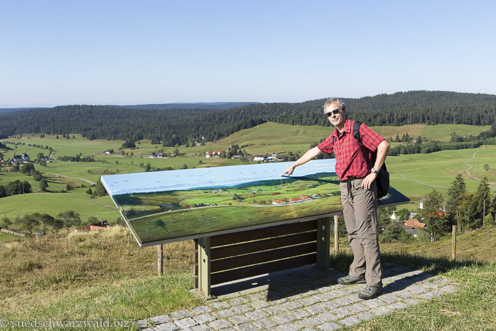 Wanderer bei der Alpenpanoramatafel beim Ibacher Friedenskreuz