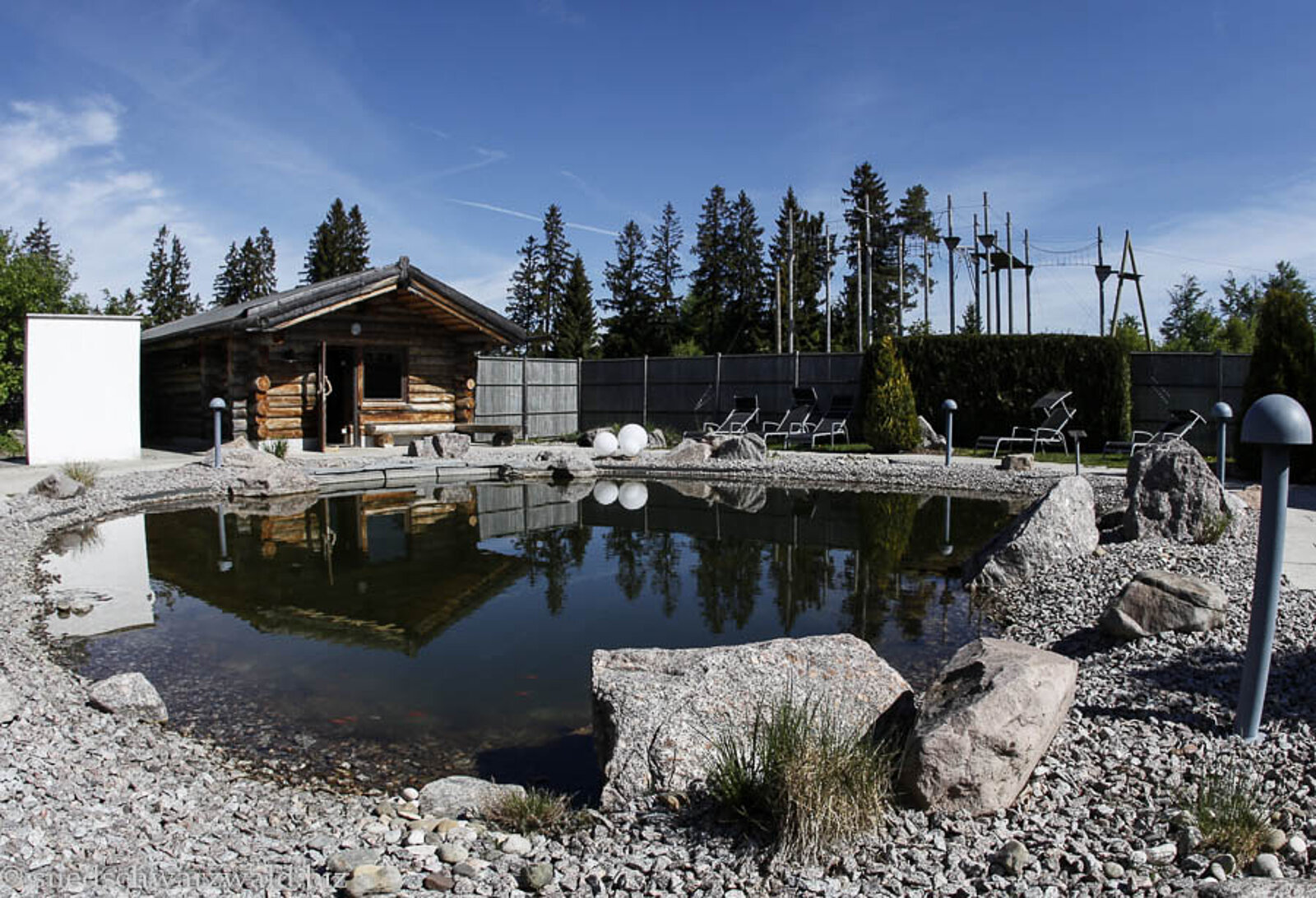 Außenbereich mit Teich und Blockhaus der Saunalandschaft Höchenschwand