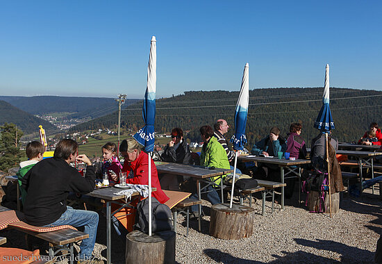 Wanderer auf der Terrasse der Glasmännlehütte auf dem Stöckerkopf bei Baiersbronn