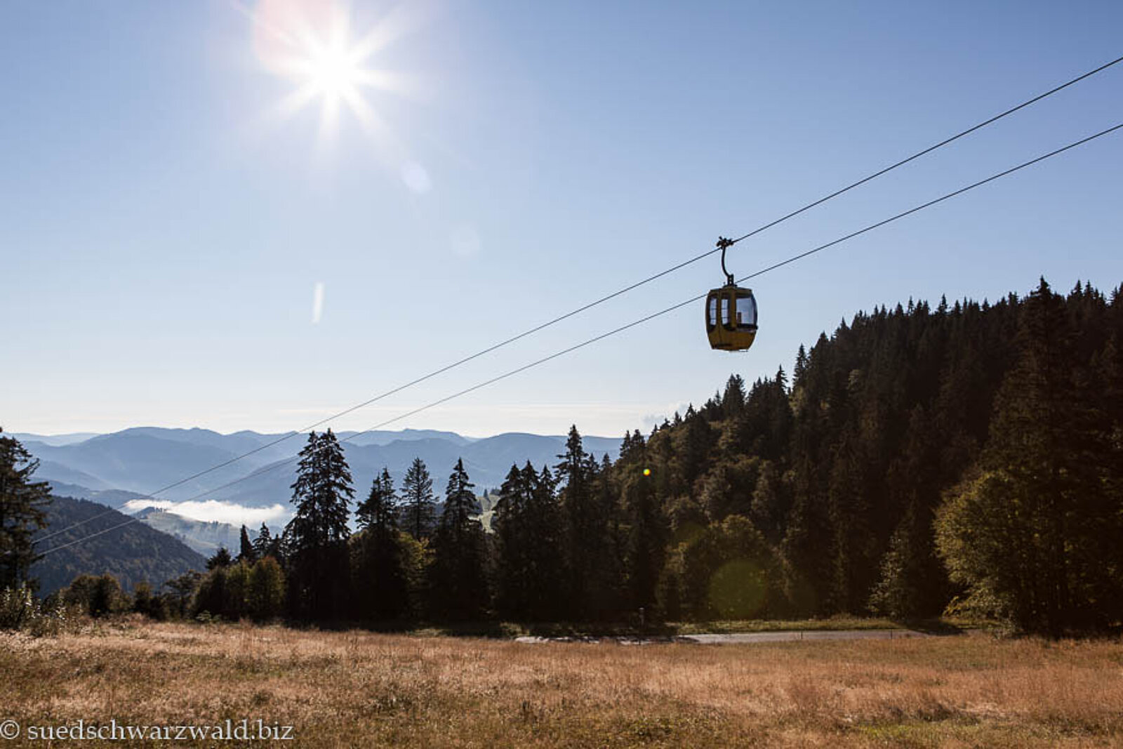 Gondel der Belchenbahn vor einem blauen Himmel mit Sonne